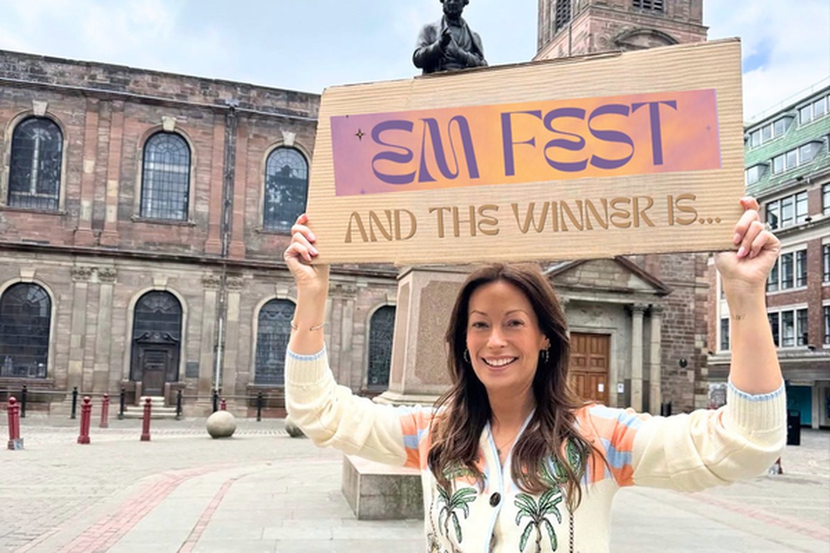 Emma Neville, founder of This Is Me, holding a sign at her annual party